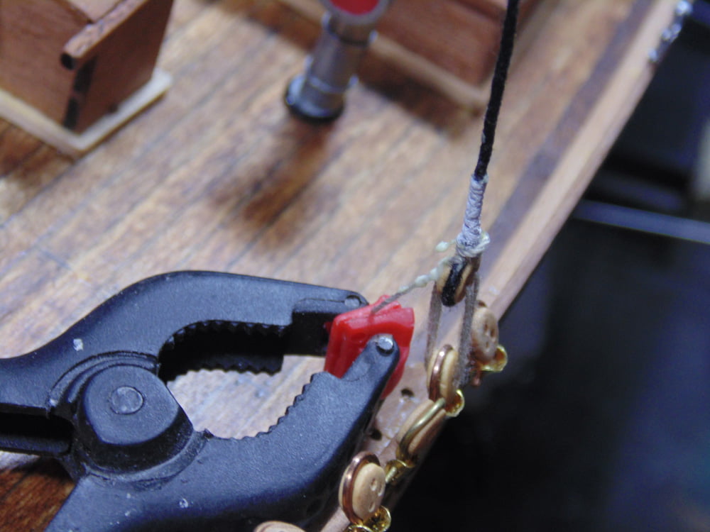 Black clamp holding thread on ships deck