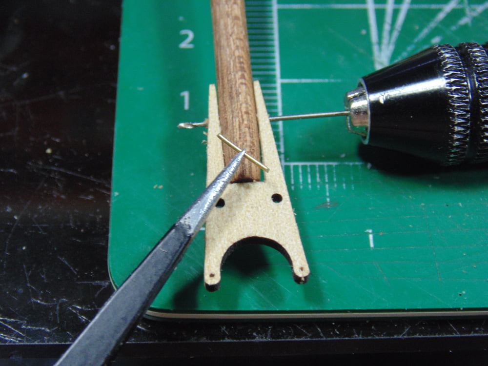 Tweezers holding pin above boom and hanger