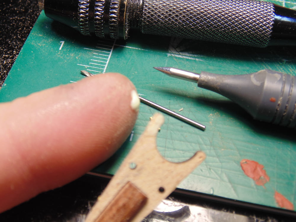 Dab of wood glue on finger next to hanger